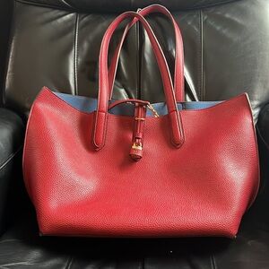 Red Tutilo pebble vegan leather tote with gold hardware. Blue interior